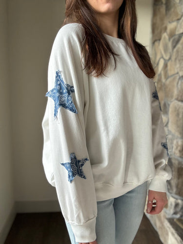 white sweatshirt with blue paisley star patches