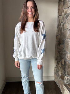 white sweatshirt with blue paisley star patches